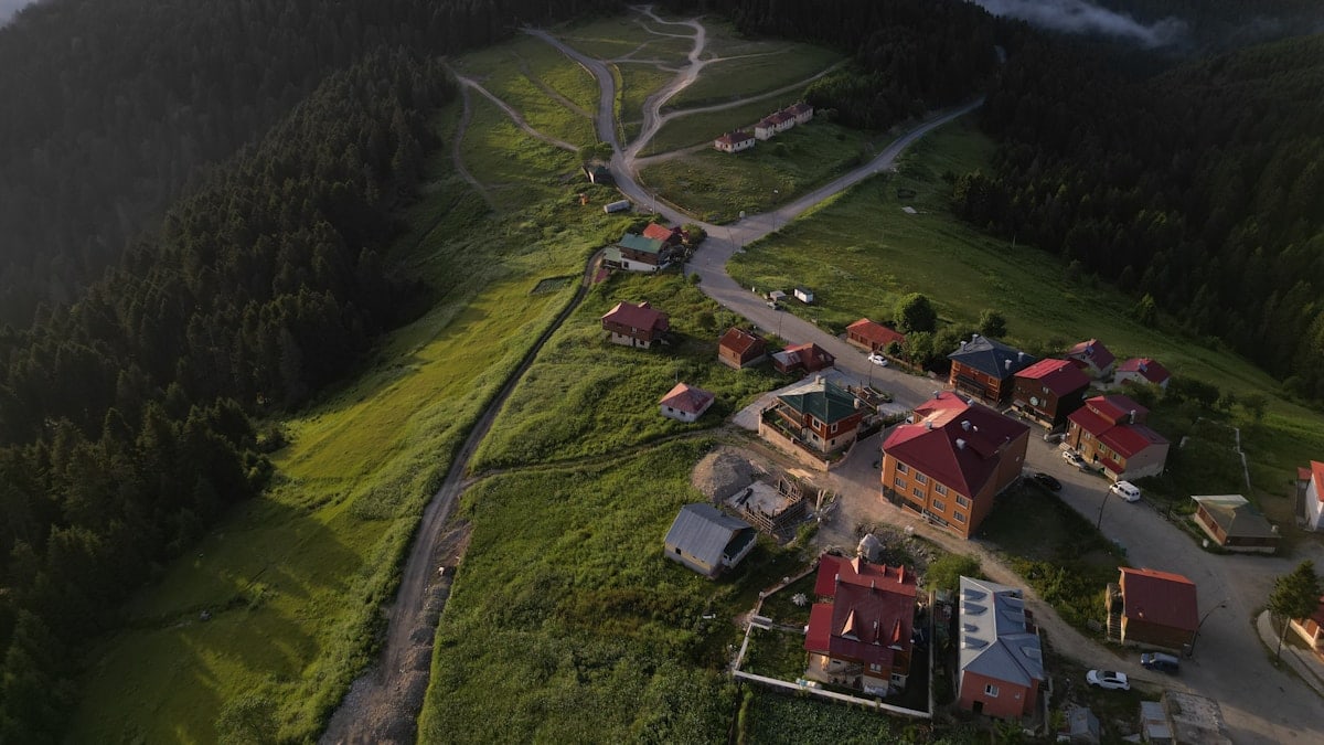 A beautiful morning in Kulakkaya, Giresun, Turkey, reveals a tranquil town nestled in lush green hills, with red-roofed houses dotting the serene landscape.